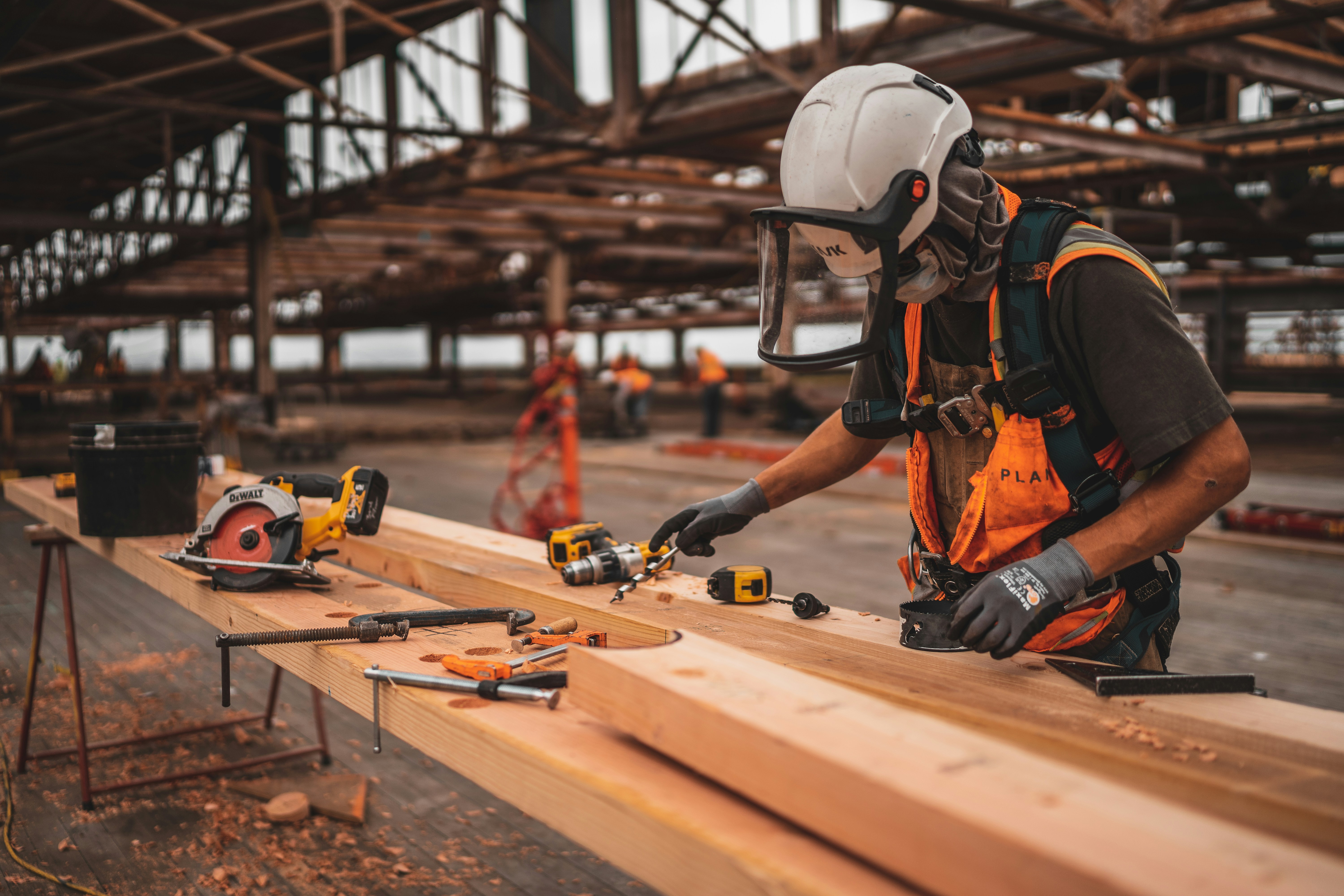 A business owner working at a construction site saying wood beams. 